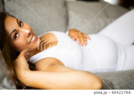Pretty pregnant woman lying on the sofa with her hand at belly 60422768