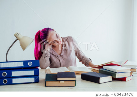 girl with pink hair sitting at a table reading a book girl with pink hair sitting at a table reading a book 60423476
