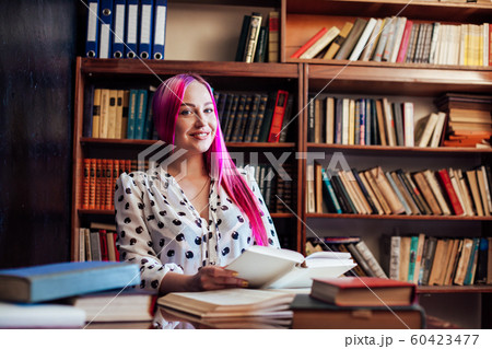 girl reading a book in the library is preparing for exams girl reading a book in the library is preparing for exams 60423477