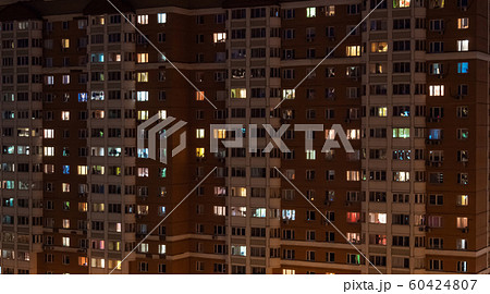 Facade view of living apartment building with glowing windows at night Facade view of living apartment building with glowing windows at night 60424807