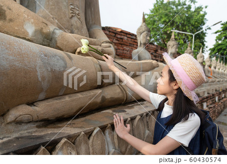 Asian girl tourist holding a lotus with respecting or pray at Wat Yai Chaimngkol, Ayutthaya,Thailand, summer vacation,travel concept. 60430574