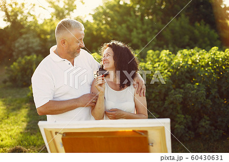 Beautiful adult couple drawing in a summer field 60430631