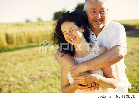 Beautiful adult couple spend time in a summer field Beautiful adult couple spend time in a summer field 60430979