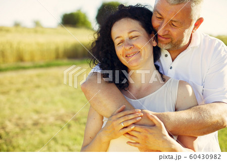 Beautiful adult couple spend time in a summer field 60430982