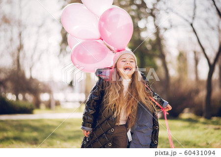 Little girl in a park playing on a grass 60431094