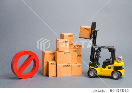 Yellow Forklift truck truckraises a box over a stack of boxes and a red symbol NO. Embargo trade wars. Restriction on importation of goods, ban on export of dual-use goods to countries under sanctions 60437810