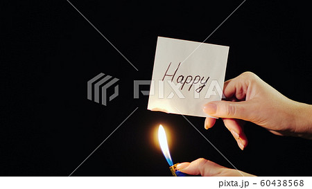 Man burns a paper with the inscription Happy 60438568