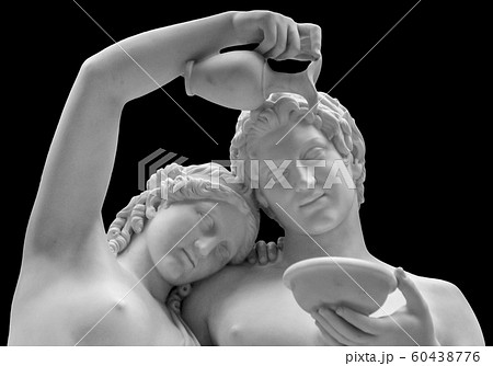 The marble sculpture of young roman couple . Close up of a sculpture of a man and women gazing lovingly into each others eyes. Young naked Roman woman and man in unity isolated on black background 60438776
