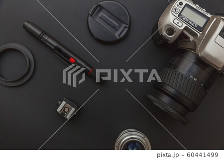 Photographer workplace with dslr camera system, camera cleaning kit, lens and camera accessory on dark black table background. Hobby travel photography concept Flat lay top view copy space 60441499