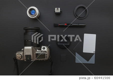 Photographer workplace with dslr camera system, camera cleaning kit, lens and camera accessory on dark black table background. Hobby travel photography concept Flat lay top view copy space 60441500