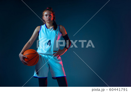 Young caucasian female basketball player on blue studio background in neon light Young caucasian female basketball player on blue studio background in neon light 60441791
