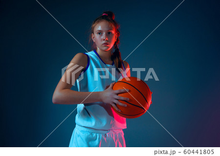 Young caucasian female basketball player on blue studio background in neon light 60441805