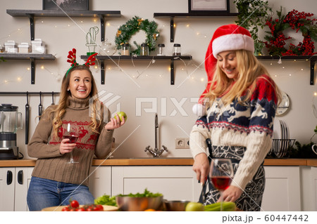 Two blonde girls prepare food for New Year in kitchen 60447442