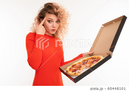 attractive curly blond girl shows thinking holding a pizza box in her hand on a white background 60448101