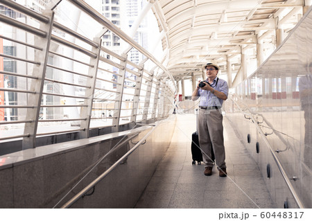 Senior man dragging luggage in the airport to to 60448317
