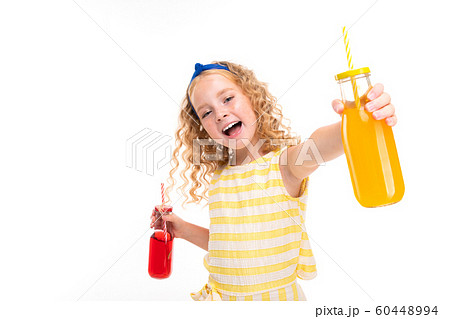 joyful blonde european girl holding two transparent glasses for cocktails in her hands on a white joyful blonde european girl holding two transparent glasses for cocktails in her hands on a white 60448994