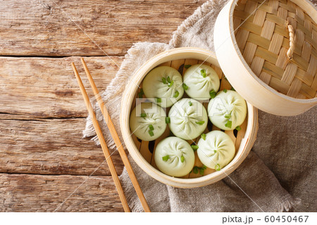 Bamboo steamer with tasty baozi dumplings closeup. Bamboo steamer with tasty baozi dumplings closeup. 60450467