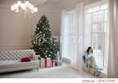 Dark-haired woman in grey shirt resting at home Dark-haired woman in grey shirt resting at home 60452449