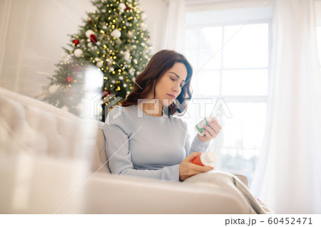 Dark-haired young woman holding pills in her hands 60452471