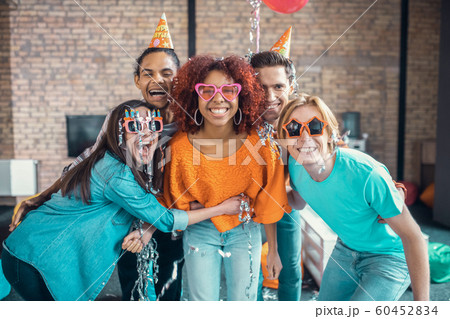 Best loving friends smiling and hugging their birthday girl Best loving friends smiling and hugging their birthday girl 60452834