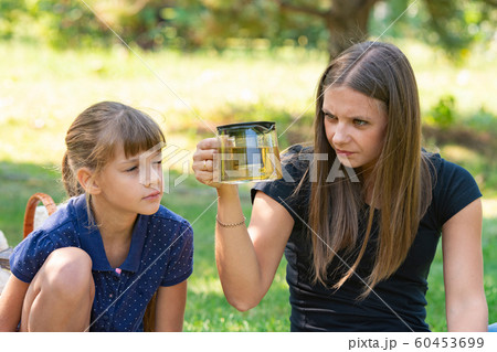 Girl and girl with interest look at a teapot at a 60453699