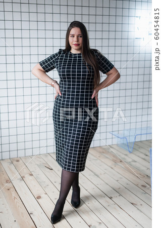 Happy beautiful and confident plus size girl posing in studio 60454815