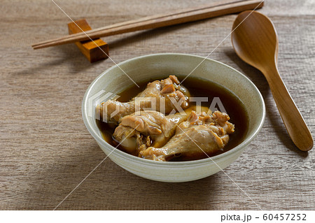 close up of chicken drumette soup in a ceramic bowl on wooden table. close up of chicken drumette soup in a ceramic bowl on wooden table. 60457252