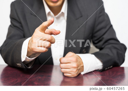 パワハライメージ 拳を握りしめて指差ししているビジネスマンの写真素材