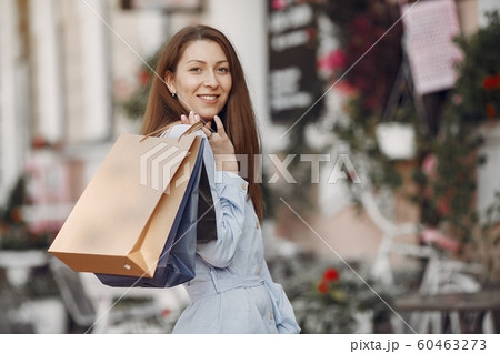 Woman in a blue dress with shopping bag in a city 60463273