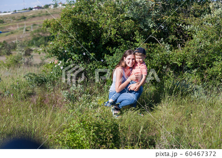 Beautiful mom with her son on a picnic rest in nature Beautiful mom with her son on a picnic rest in nature 60467372