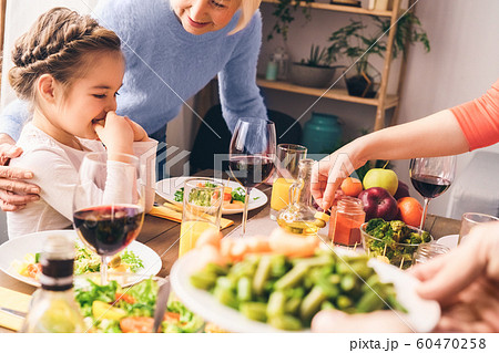 Family sitting at home behind table with yummy food 60470258