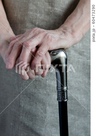 Hands of an elderly woman holding a cane. Hands of an elderly woman holding a cane. 60473290
