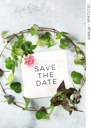 Save the date, an invitation design template with a flat lay wreath of leaves and flowers and a place for text, top shot. Ivy and rose frame 60473712