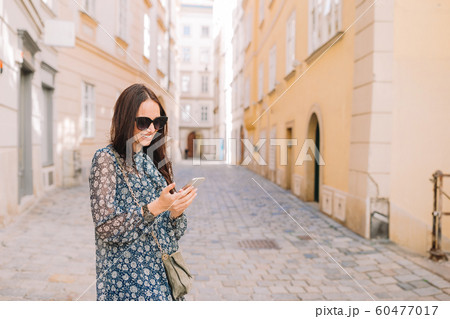 Woman talk by her smartphone in city. Young attractive tourist outdoors in italian city 60477017