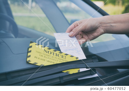 Parking ticket under windshield wiper Parking ticket under windshield wiper 60477052
