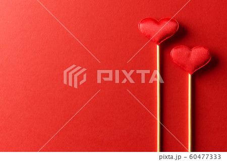 Red textile hearts on wooden sticks closeup 60477333