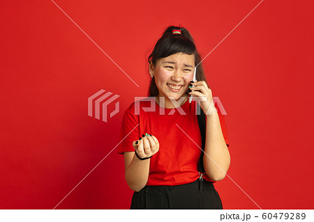 Asian teenager's portrait isolated on red studio background 60479289