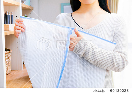 洗濯ネットを持つ女性 粗目 洗濯ネットを持つ女性 粗目 60480028