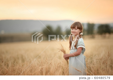 Baby girl farmer in natural Golden wheat field Baby girl farmer in natural Golden wheat field 60480579