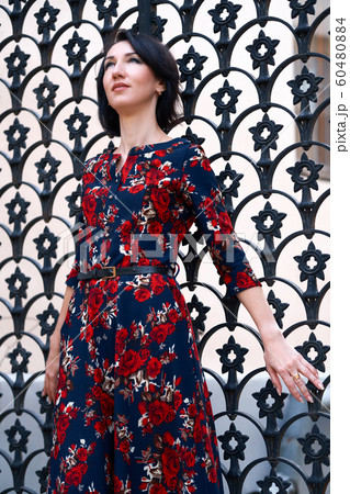 Beautiful elegant woman posing near black wrought Beautiful elegant woman posing near black wrought 60480884