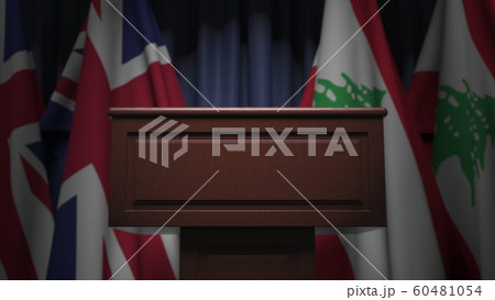 Many flags of Lebanon and the United Kingdom behind speaker tribune, 3D rendering Many flags of Lebanon and the United Kingdom behind speaker tribune, 3D rendering 60481054