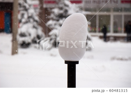 Street lamp with a snow cap IN THE SNOW WINTER STREET. 60481315