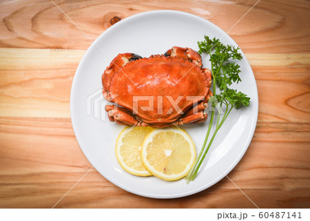 Cooked crab on white plate with lemon herbs and 60487141