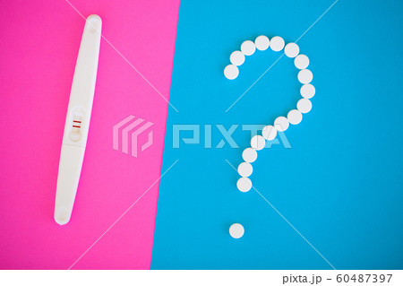 Pregnancy test. The result is positive with two strips and condom with contraceptive on colored background, Birth control pill, safe sex, healthcare concep 60487397