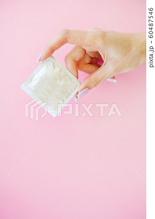 Contraception. Birth Control Pills and an unwrapped Condom. Colored Pills And Capsule On Pink Background. Pharmacy Theme, Capsule Pills With Medicine Antibiotic in Packages 60487546