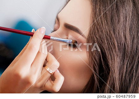 make-up artist doing make-up girl in the salon, beauty concept make-up artist doing make-up girl in the salon, beauty concept 60487959