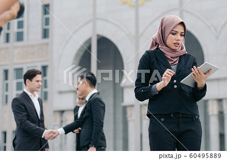 unhappy expression, young businesswoman standing 60495889