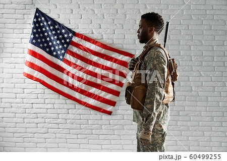 Side view of American soldier near national flag. Side view of American soldier near national flag. 60499255