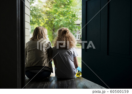 Mother and daughter sitting on porch Mother and daughter sitting on porch 60500159