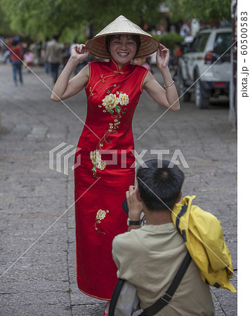 Man photographing woman wearing red dress in Lijang, Shangri-La Region, Yunnan Province, China Man photographing woman wearing red dress in Lijang, Shangri-La Region, Yunnan Province, China 60500583
